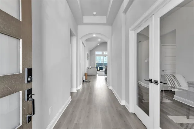 a view of a hallway with wooden floor and staircase