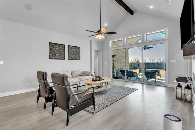 a living room with furniture a flat screen tv and a large window