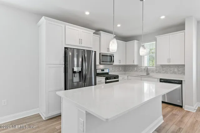 a kitchen with stainless steel appliances a refrigerator sink and microwave