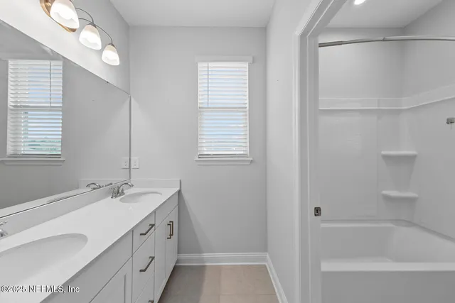 a bathroom with a tub sink and mirror