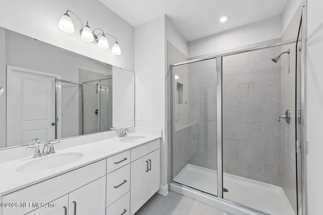 a bathroom with double vanity sinks and a mirror