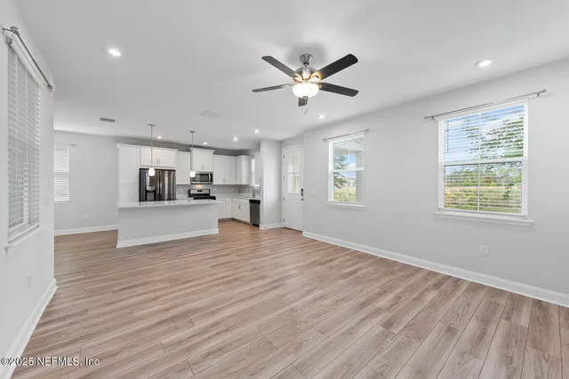a view of a kitchen with wooden floor and a window
