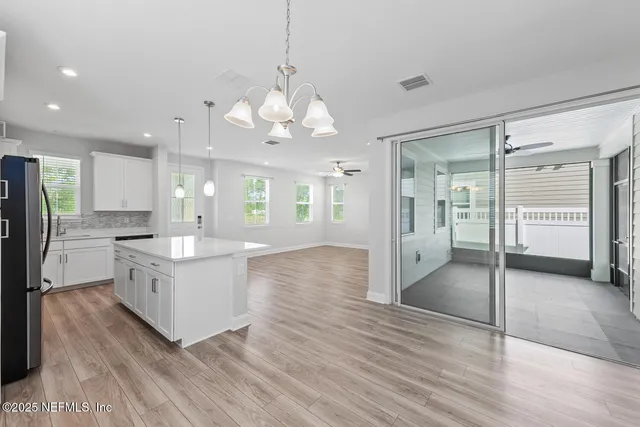 a large kitchen with granite countertop a large counter top and stainless steel appliances