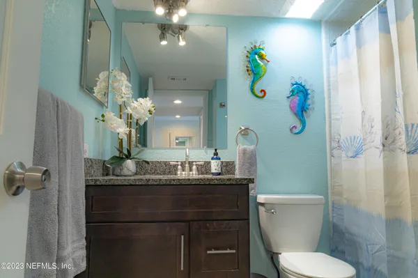 a bathroom with a sink mirror vanity and toilet
