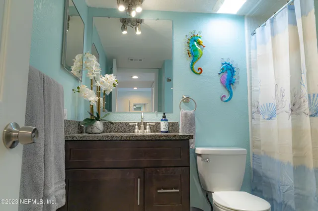 a bathroom with a sink mirror vanity and toilet