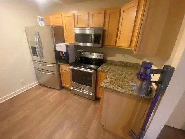 a kitchen with stainless steel appliances a stove a refrigerator a microwave a sink and cabinets
