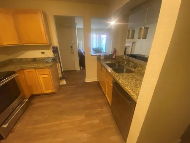 a kitchen with granite countertop a sink and refrigerator