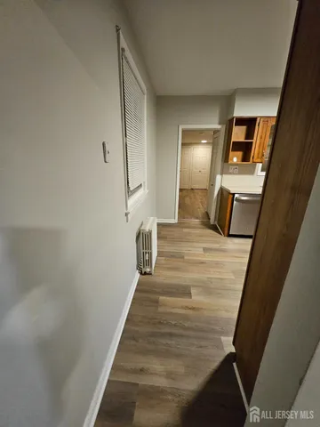 a view of a hallway with wooden floor and stairs
