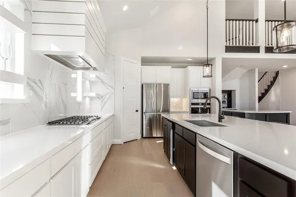 a kitchen with stainless steel appliances granite countertop a sink stove and refrigerator