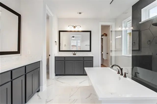 a bathroom with a bathtub sink and mirror