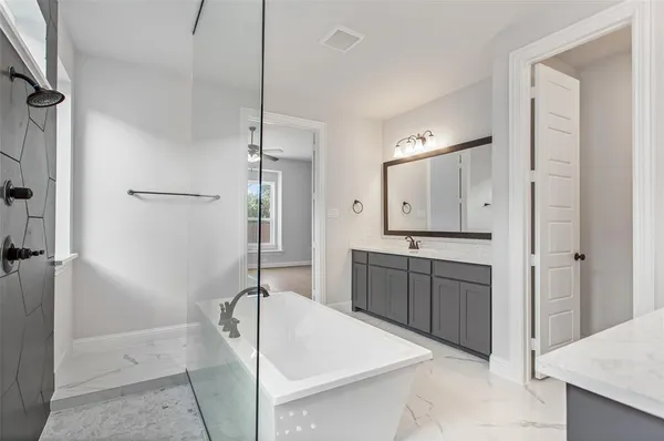 a spacious bathroom with a granite countertop sink mirror and shower