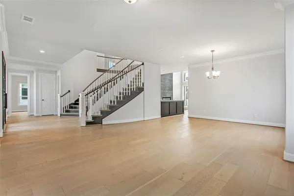 a view of an empty room with stairs and a window