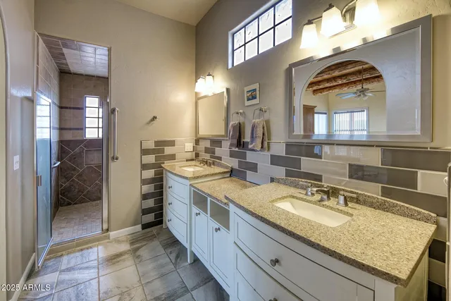 a bathroom with a granite countertop sink a mirror and a shower