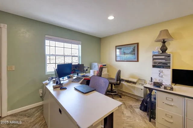 a spacious bedroom with a bed a table in it and a large mirror