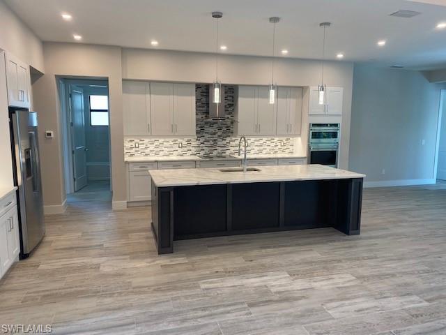 10 Willoughby Drive Naples, FL 34110 - Photo 2 of 11 a view of kitchen with kitchen island refrigerator and wooden floor