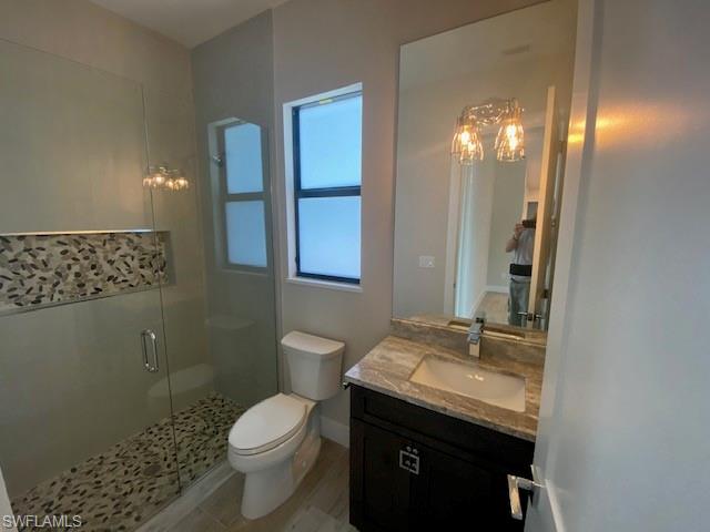 10 Willoughby Drive Naples, FL 34110 - Photo 10 of 11 a bathroom with a granite countertop sink a toilet and a mirror