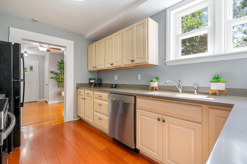 412 Worcester Road Barre, MA 01005 - Photo 11 of 31 a kitchen with white cabinets a sink a window and stainless steel appliances