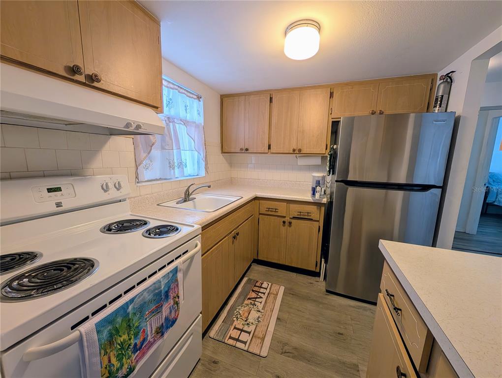 5929 Easy Street, Unit I23 Bradenton, FL 34207 - Photo 4 of 24 a kitchen with a stove a refrigerator and a sink