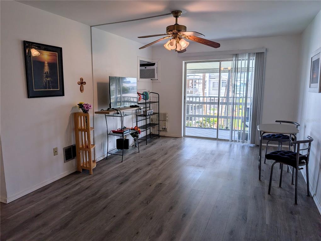 5929 Easy Street, Unit I23 Bradenton, FL 34207 - Photo 8 of 24 a view of a livingroom with furniture hardwood ceiling fan and windows