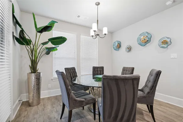 a view of a dining room with furniture a chandelier and wooden floor