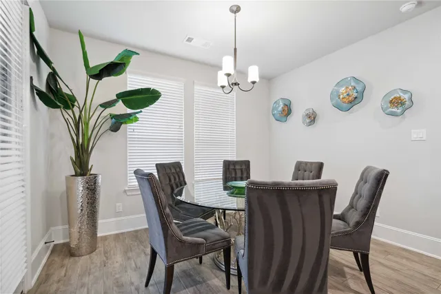 a view of a dining room with furniture a chandelier and wooden floor