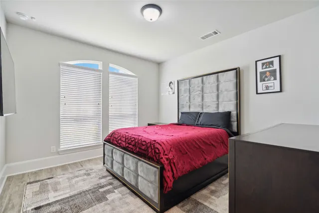 a bedroom with a large bed and a window