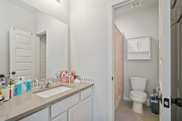 a bathroom with a granite countertop sink toilet and a mirror