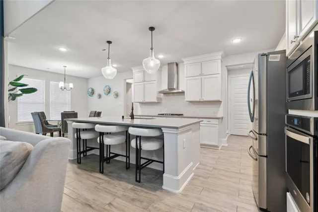 a kitchen with stainless steel appliances kitchen island granite countertop a table chairs sink and cabinets
