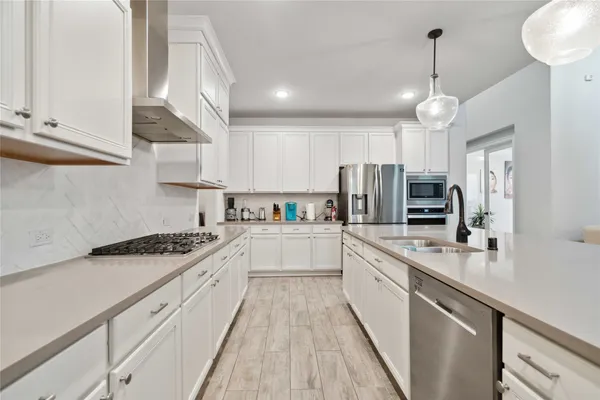 a large kitchen with stainless steel appliances lots of counter space a sink and cabinets