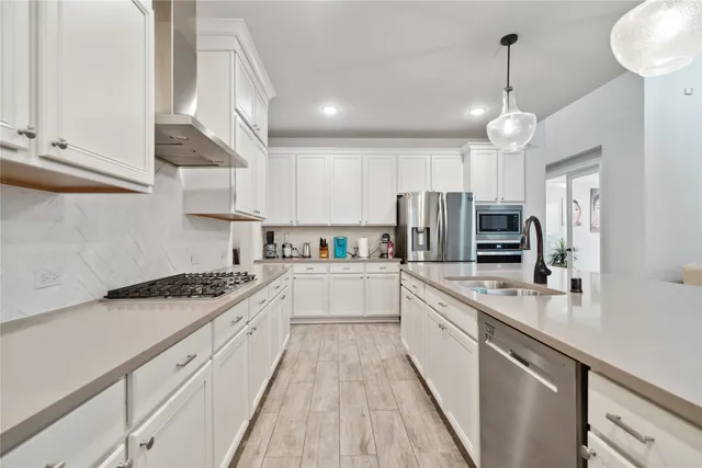 a large kitchen with stainless steel appliances lots of counter space a sink and cabinets
