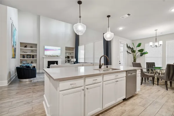 a large kitchen with stainless steel appliances kitchen island granite countertop a sink a stove and a wooden floors