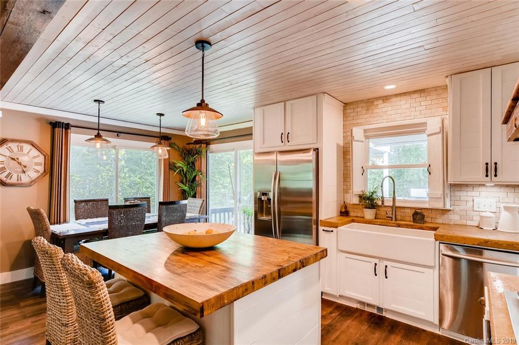 10840 Valley Hill Road Indian Land, SC 29707 - Photo 12 of 37 a kitchen with stainless steel appliances kitchen island granite countertop a stove a refrigerator a sink a dining table and chairs with wooden floor