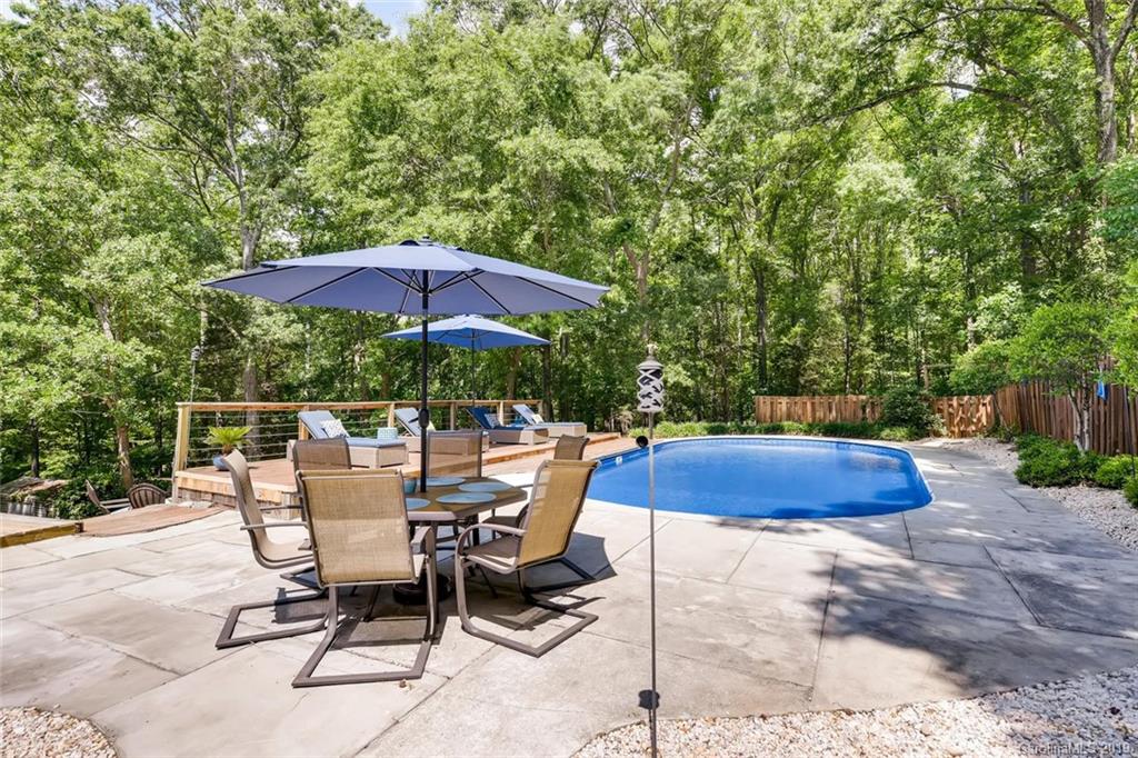 10840 Valley Hill Road Indian Land, SC 29707 - Photo 32 of 37 a patio with a table and chairs under an umbrella