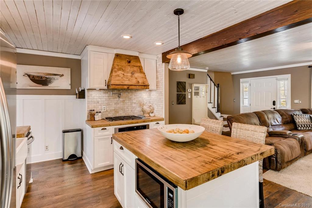 10840 Valley Hill Road Indian Land, SC 29707 - Photo 10 of 37 a kitchen with a stove a sink a kitchen island with wooden floor and cabinets