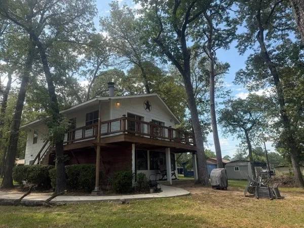 a view of a house with a yard balcony and a tree