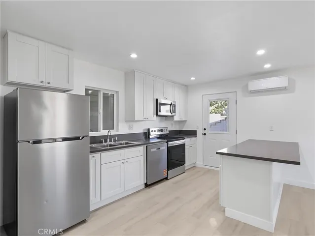 a kitchen with stainless steel appliances granite countertop a refrigerator sink and stove