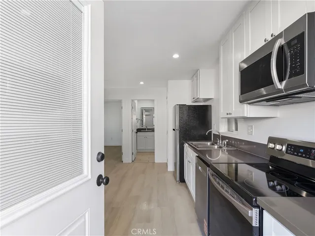 a kitchen with stainless steel appliances a stove microwave and sink