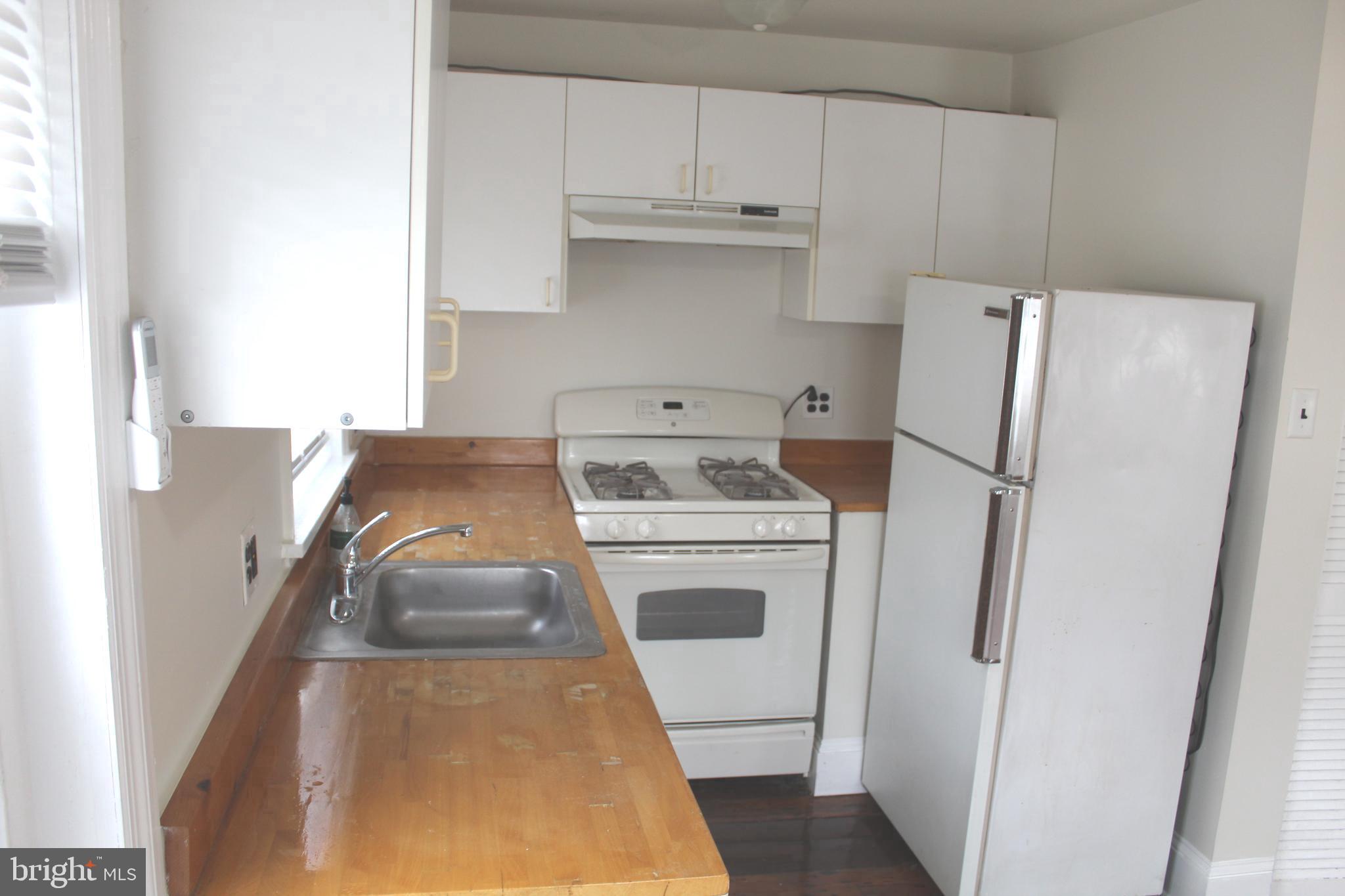 4417 Baker Street Philadelphia, PA 19127 - Photo 34 of 50 a kitchen with refrigerator a stove a sink and a window