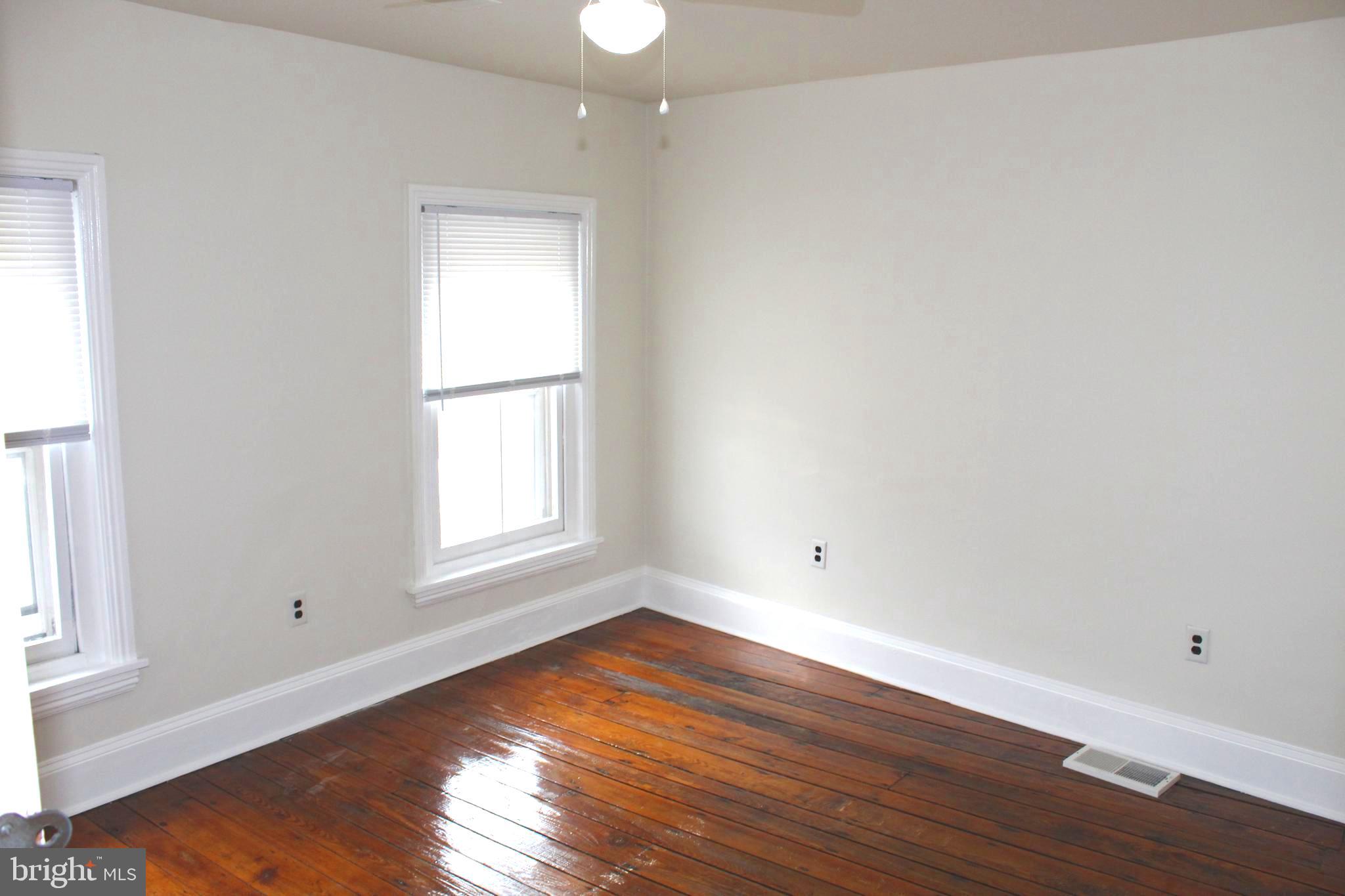 4417 Baker Street Philadelphia, PA 19127 - Photo 47 of 50 an empty room with wooden floor and windows