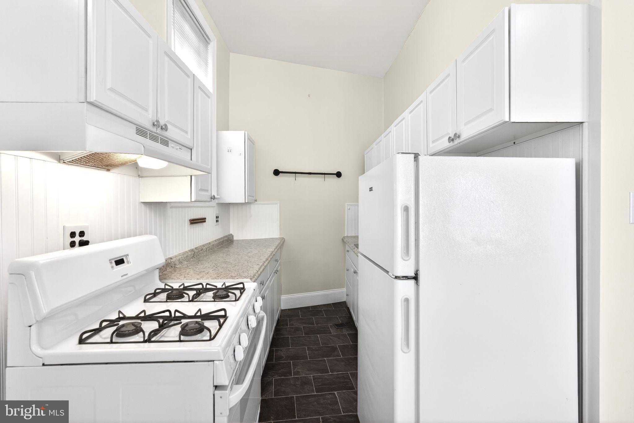 4417 Baker Street Philadelphia, PA 19127 - Photo 5 of 50 a kitchen with a white stove and refrigerator