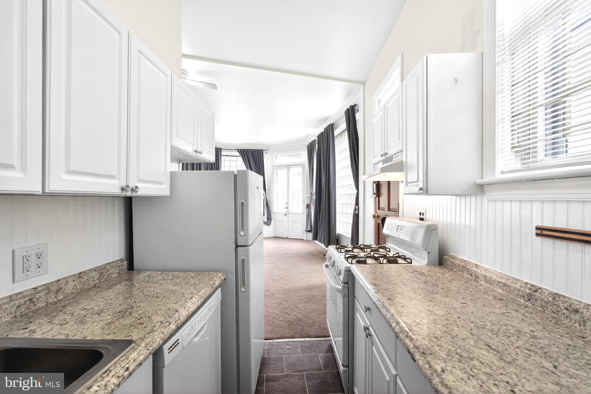 4417 Baker Street Philadelphia, PA 19127 - Photo 6 of 50 a kitchen with granite countertop a sink stove and refrigerator
