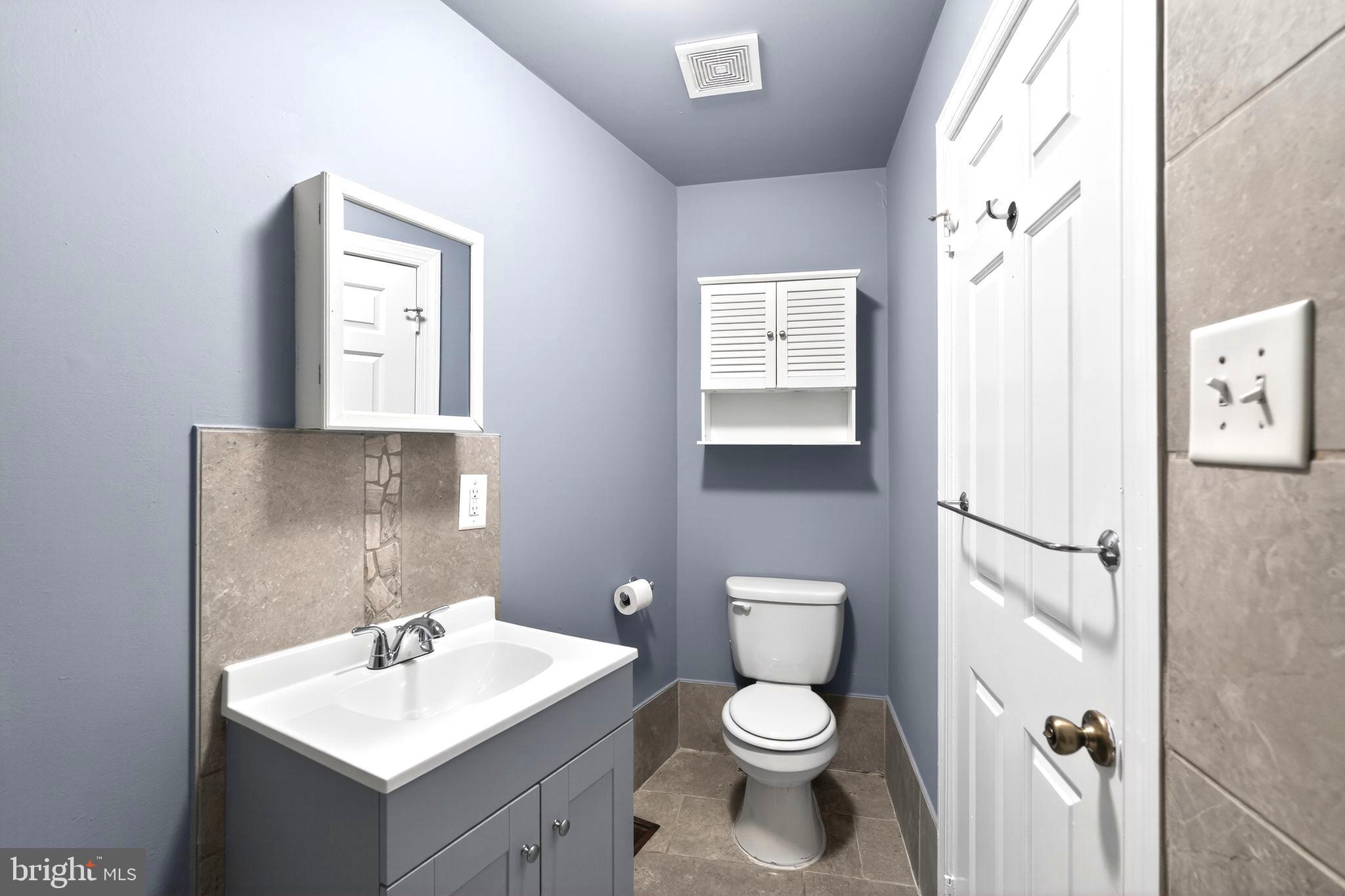 4417 Baker Street Philadelphia, PA 19127 - Photo 7 of 50 a bathroom with a toilet sink and a mirror
