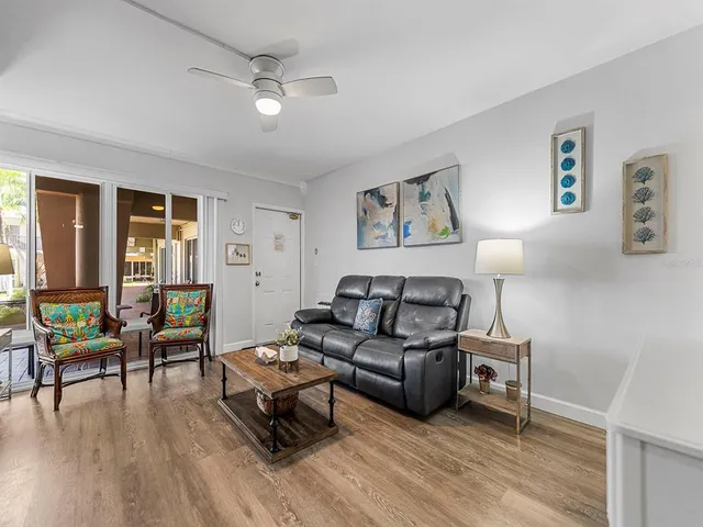 a kitchen with stainless steel appliances granite countertop a dining table chairs cabinets and a sink