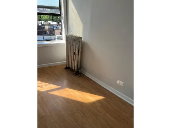 a view of a livingroom with wooden floor and a window