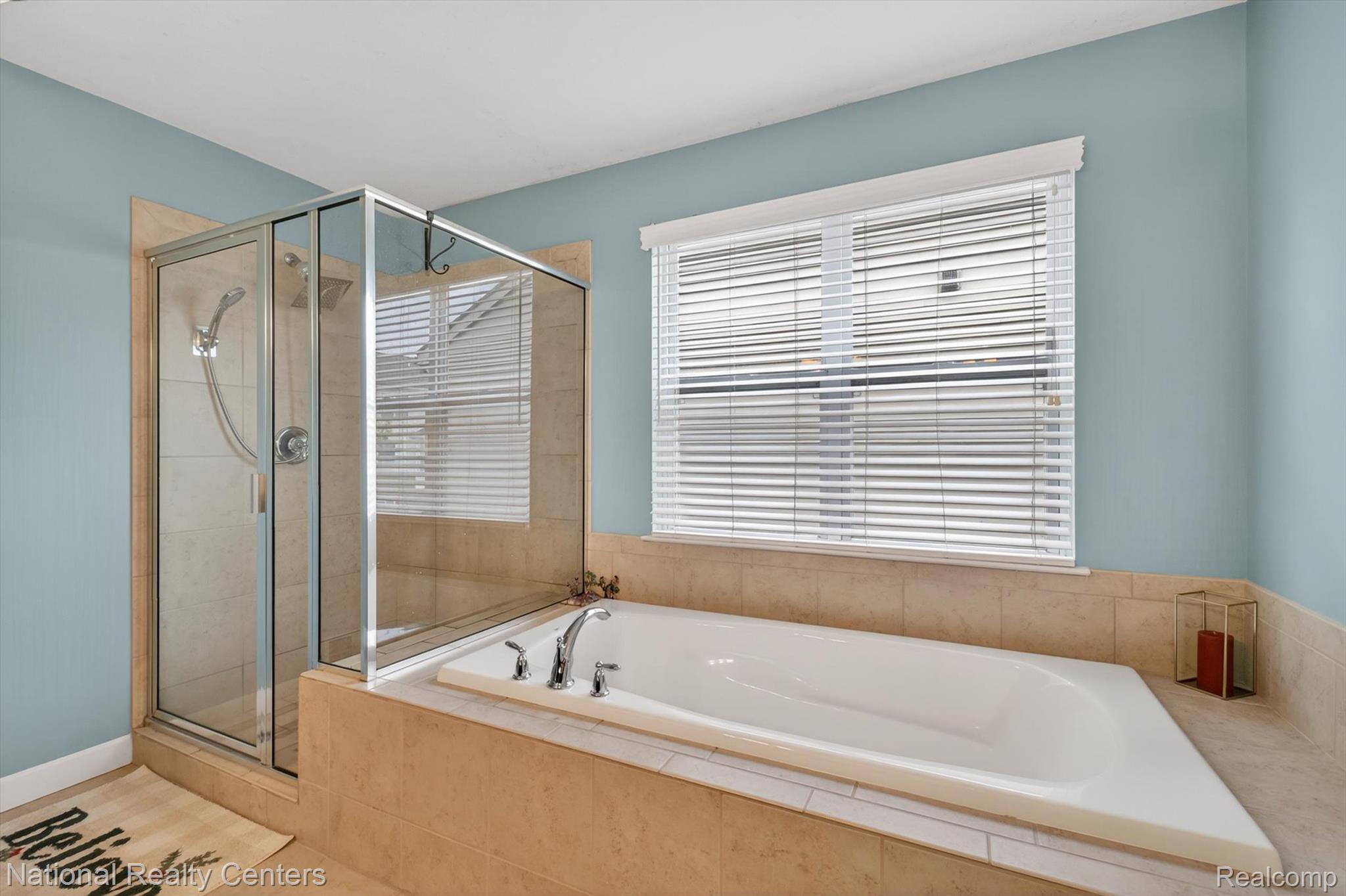 27412 Victoria Road Novi, MI 48374 - Photo 27 of 61 Soaking tub with chrome fixtures, surrounded by neutral-toned tile and a window with blinds