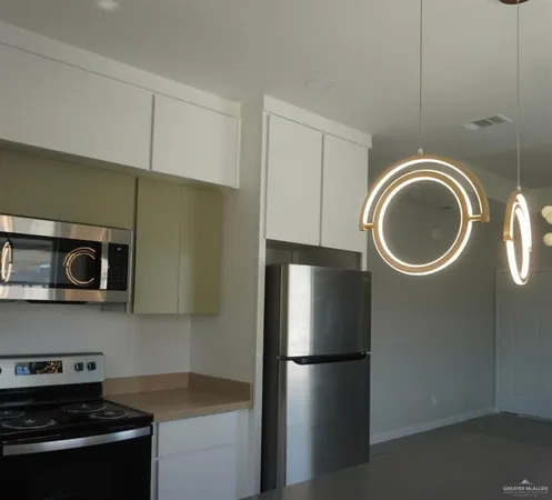 a kitchen with a refrigerator and a stove top oven