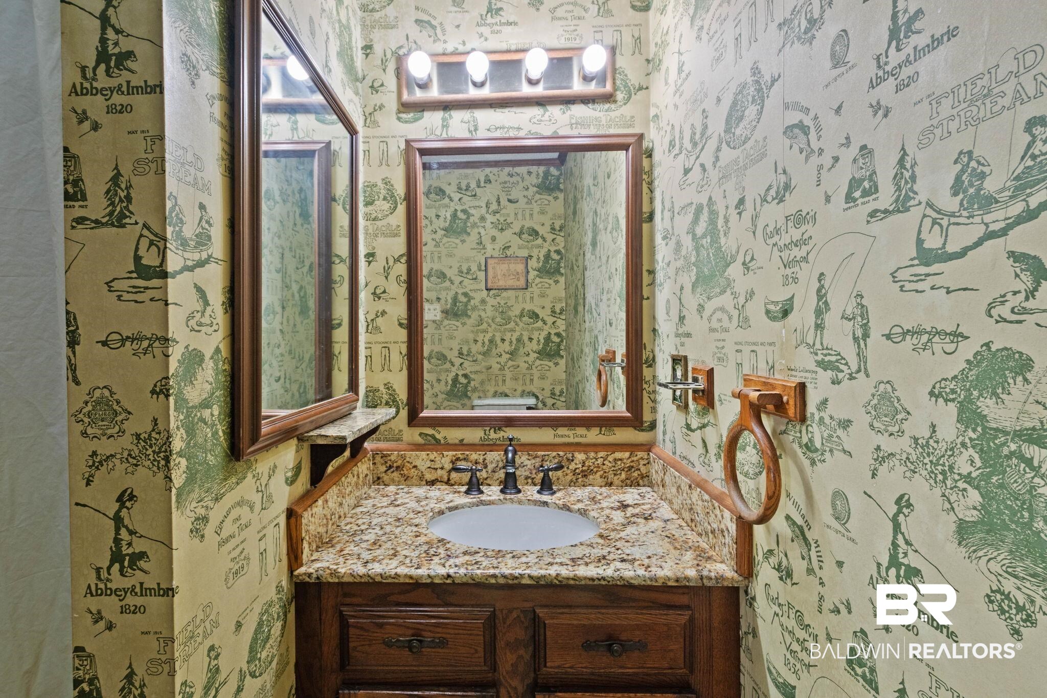 8153 Bryant's Lndg Road Stockton, AL 36579 - Photo 40 of 87 Powder room featuring a wood vanity with a granite-style countertop, undermount sink, and a framed mirror
