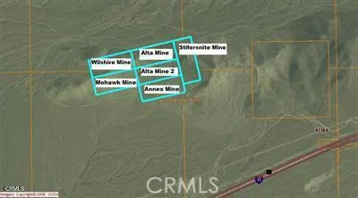 a view of a dry yard with mountains in the background