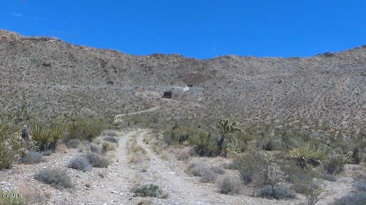 65845 Cima Road Baker, CA 92309 - Photo 16 of 61 a view of a dry yard with mountains in the background