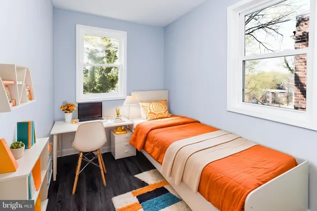 a bedroom with a bed a window and a lamp